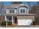Charming two-story home with stone accents, gray siding, and a two-car garage at 4940 Heathshire Dr, Raleigh, NC 27616