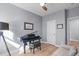Living room with hardwood floors, a grand piano, leather couch, and modern lighting at 50 Sneed Ln, Fuquay Varina, NC 27526
