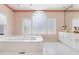 Bright bathroom featuring a large soaking tub, white cabinets, and decorative wallpaper at 50002 Brogden, Chapel Hill, NC 27517