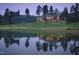 Beautiful evening home exterior on a golf course reflecting on the lake, framed by mature trees at 50002 Brogden, Chapel Hill, NC 27517