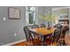 Cozy dining area with wood table and chairs next to a window, and a view into the bedroom at 506 N Mangum St # 303, Durham, NC 27701