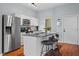 Well-equipped kitchen with a stainless steel refrigerator, an island with seating, and modern finishes at 506 N Mangum St # 303, Durham, NC 27701