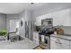 Stylish kitchen featuring stainless steel appliances, white cabinetry, and trendy backsplash at 506 N Mangum St # 303, Durham, NC 27701