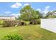 View of the backyard with healthy green grass, shrubs, and a white fence at 510 Berry Chase Way, Cary, NC 27519