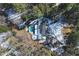 Aerial view of an estate with backyard swimming pool, and circular drive nestled among trees covered in winter snow at 515 S Woodland Rd, Henderson, NC 27536