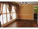 Bright dining room featuring hardwood floors, a modern chandelier, and shuttered windows for ample natural light at 515 S Woodland Rd, Henderson, NC 27536