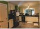 Spacious kitchen featuring stainless steel appliances, white cabinets, and dark granite countertops at 515 S Woodland Rd, Henderson, NC 27536