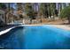 Inviting in-ground pool with surrounding patio and landscaped yard at 515 S Woodland Rd, Henderson, NC 27536