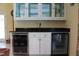 Home wet bar featuring granite countertops, display cabinets, and wine and beverage coolers at 515 S Woodland Rd, Henderson, NC 27536