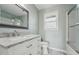 Bathroom featuring marble vanity, framed mirror, and tiled shower with glass door at 5704 Whippoorwill St, Durham, NC 27704