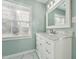 Bathroom featuring a marble vanity, framed mirror, and window at 5704 Whippoorwill St, Durham, NC 27704
