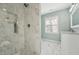 Bathroom featuring a marble shower, white vanity, and window at 5704 Whippoorwill St, Durham, NC 27704