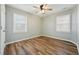 Neutrally painted bedroom features wood-look floors, two windows, and white trim at 5704 Whippoorwill St, Durham, NC 27704