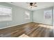 Neutral bedroom featuring wood-look floors, windows, and white trim at 5704 Whippoorwill St, Durham, NC 27704