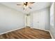 Neutral bedroom featuring wood-look floors, closet doors, and ceiling fan at 5704 Whippoorwill St, Durham, NC 27704