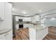 Bright kitchen featuring white cabinets, granite countertops, and stainless steel appliances at 5704 Whippoorwill St, Durham, NC 27704