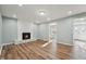 Bright living room with a cozy fireplace, neutral walls, and attractive hardwood floors at 5704 Whippoorwill St, Durham, NC 27704