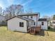 Rear exterior view of a white two-story home featuring a wooden deck and well-maintained lawn at 5704 Whippoorwill St, Durham, NC 27704
