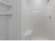 Bright bathroom featuring a shower with white tile and glass shelves at 5900 Damon Ct, Raleigh, NC 27610