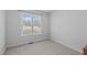 Cozy bedroom with a neutral carpet and a large window providing natural light at 5900 Damon Ct, Raleigh, NC 27610