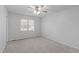 Bedroom with a ceiling fan and neutral carpet, complemented by a large window at 5900 Damon Ct, Raleigh, NC 27610