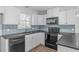 Stylish kitchen showcasing black appliances and a beautiful blue backsplash at 5900 Damon Ct, Raleigh, NC 27610