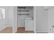 Laundry room with white washer, floating shelves, and white doors for convenience and storage at 5900 Damon Ct, Raleigh, NC 27610