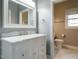 Bathroom with white marble countertop, white cabinetry, and a view into the adjacent toilet room at 5917 Sentinel Dr, Raleigh, NC 27609