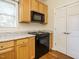 Kitchen featuring granite counters, light wood cabinetry, and black appliances at 5917 Sentinel Dr, Raleigh, NC 27609