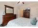 Bright bedroom featuring dark wood dresser with television and coordinating bedding at 6236 Annabella Rd, Rocky Mount, NC 27803