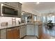 Well-equipped kitchen with stainless steel appliances, gray cabinets, and a view into the living and dining areas at 6236 Annabella Rd, Rocky Mount, NC 27803