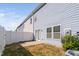 A private backyard with a white fence, small patio, and easy access to the home through sliding glass doors at 624 Metro Station, Apex, NC 27502