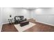 Basement with dark leather sofa and ottoman on a neutral rug with dark wood-look flooring at 624 Metro Station, Apex, NC 27502