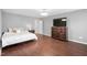 Spacious bedroom features a dark wood floor, neutral colored walls, and a matching dark wood dresser at 624 Metro Station, Apex, NC 27502