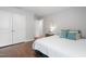 Bright primary bedroom featuring a white bed and wood floors at 624 Metro Station, Apex, NC 27502