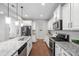 Bright kitchen boasts granite countertops, white cabinets, and stainless steel appliances at 624 Metro Station, Apex, NC 27502