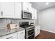 Kitchen with white cabinets, granite countertops, a gas range, and stainless steel microwave at 624 Metro Station, Apex, NC 27502