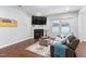 Comfortable living room showcasing a fireplace, mounted TV, hardwood floors, and ample natural light at 624 Metro Station, Apex, NC 27502