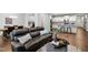 Open-concept living room connecting the kitchen and dining area with hardwood floors and modern furnishings at 624 Metro Station, Apex, NC 27502