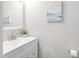 Well-lit powder room with white vanity, silver faucet, modern mirror, and neutral wall paint at 624 Metro Station, Apex, NC 27502