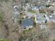 Aerial view of a home with a backyard deck and a pool surrounded by lush trees in a quiet neighborhood at 8720 Deerland Grove Dr, Raleigh, NC 27615