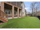 Landscaped backyard with artificial turf, a covered patio, and a view of the home's exterior at 8720 Deerland Grove Dr, Raleigh, NC 27615