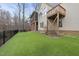 Expansive backyard featuring artificial turf, a wooden deck, and a screened-in porch at 8720 Deerland Grove Dr, Raleigh, NC 27615