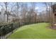 Large backyard featuring manicured lawn, privacy fence, and wooded views at 8720 Deerland Grove Dr, Raleigh, NC 27615