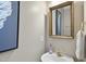 Powder room featuring a pedestal sink, gold faucet and gold framed mirror at 8720 Deerland Grove Dr, Raleigh, NC 27615