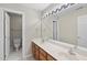 Bathroom with double sink vanity, large mirror, and a separate toilet room at 8720 Deerland Grove Dr, Raleigh, NC 27615