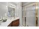 Bathroom featuring a walk in shower with gold trim, white countertops, and dark cabinets at 8720 Deerland Grove Dr, Raleigh, NC 27615