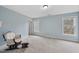 Bright bedroom featuring a rocking chair, light blue walls, and a window overlooking a backyard at 8720 Deerland Grove Dr, Raleigh, NC 27615