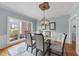 Elegant dining room featuring a glass-top table, stylish chairs, and a modern chandelier with natural light at 8720 Deerland Grove Dr, Raleigh, NC 27615