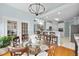 Bright dining area with glass table and views to kitchen and living room at 8720 Deerland Grove Dr, Raleigh, NC 27615